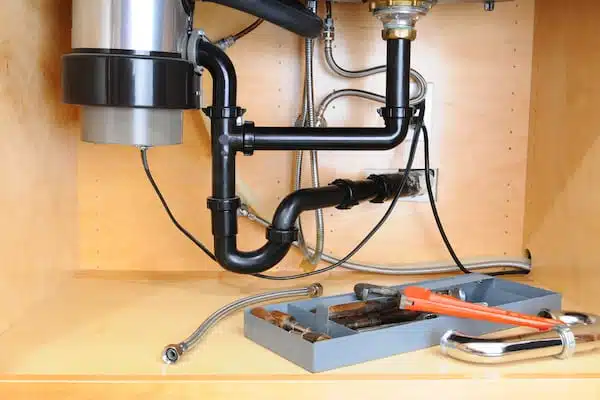 garbage disposal in a cabinet beneath kitchen sink