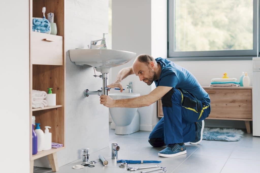 Plumber working on a bathroom plumbing system upgrade.