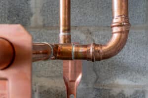 Copper pipe plumbing connections and fittings for new potable water pipes in a bathroom, Benefits of Retrofitting Your Home's Plumbing.