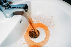 A bathroom faucet emitting rust colored water