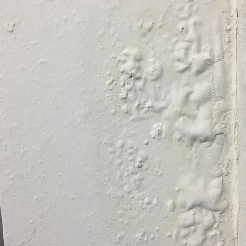 A home wall bubbles and blisters from water damage.